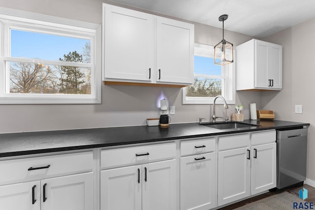 kitchen featuring decorative light fixtures, sink, white cabinetry, and stainless steel dishwasher