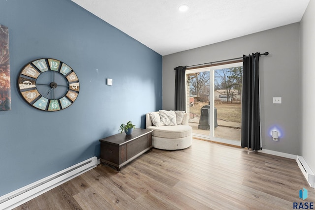 sitting room featuring a baseboard heating unit and light hardwood / wood-style floors