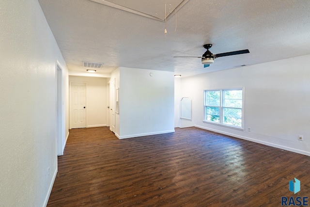 empty room with ceiling fan, a textured ceiling, and dark hardwood / wood-style floors