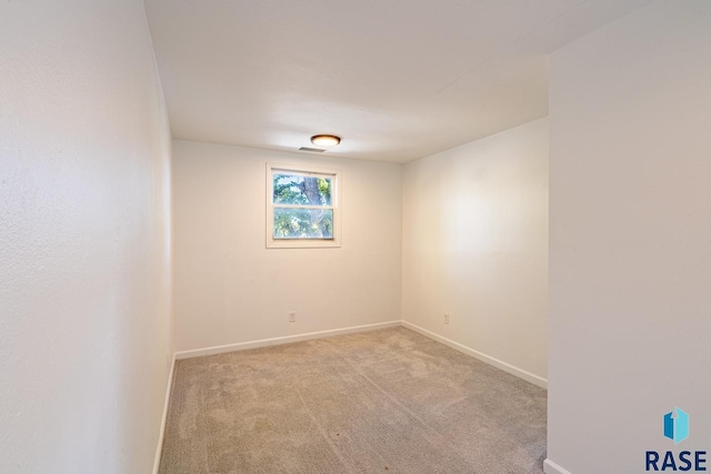 unfurnished room featuring light carpet