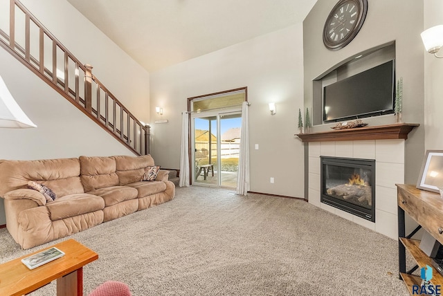 living room with vaulted ceiling, a fireplace, and carpet flooring