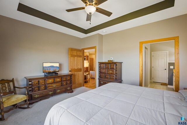 bedroom with ceiling fan and a tray ceiling