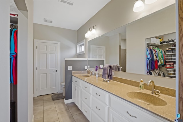 bathroom featuring toilet, tile patterned flooring, and vanity