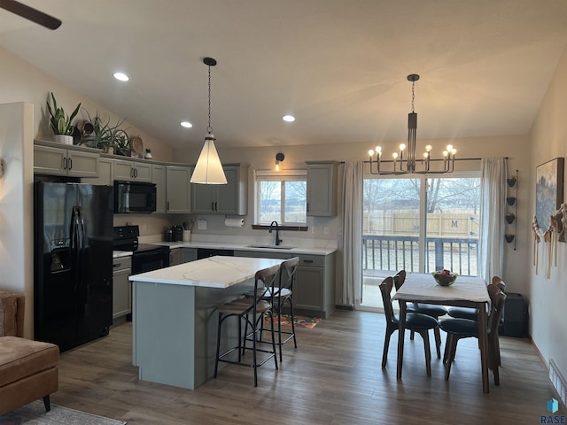 kitchen featuring an inviting chandelier, gray cabinets, hanging light fixtures, a kitchen island, and black appliances