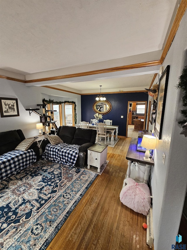 living room with wood-type flooring, beamed ceiling, an inviting chandelier, and a textured ceiling