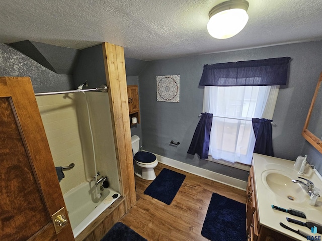 full bathroom with tub / shower combination, a textured ceiling, wood-type flooring, vanity, and toilet