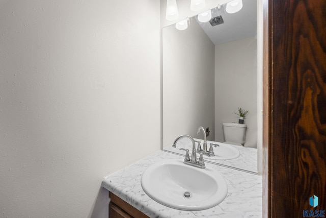 half bath featuring toilet and vanity