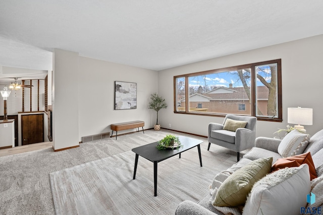 living area featuring carpet flooring, visible vents, and baseboards