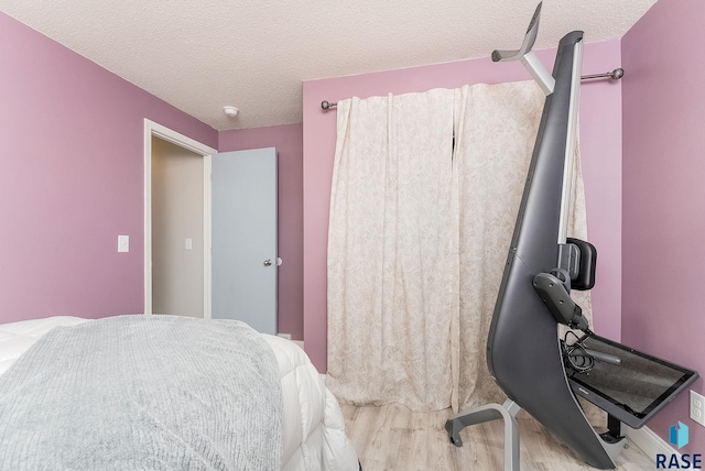 bedroom featuring a textured ceiling and light hardwood / wood-style flooring