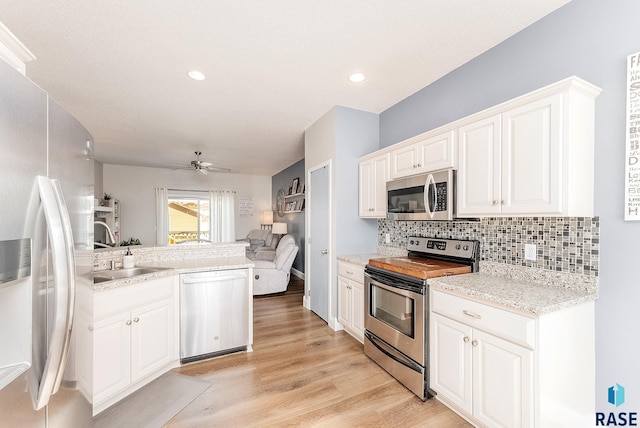 kitchen featuring ceiling fan, sink, white cabinets, and stainless steel appliances