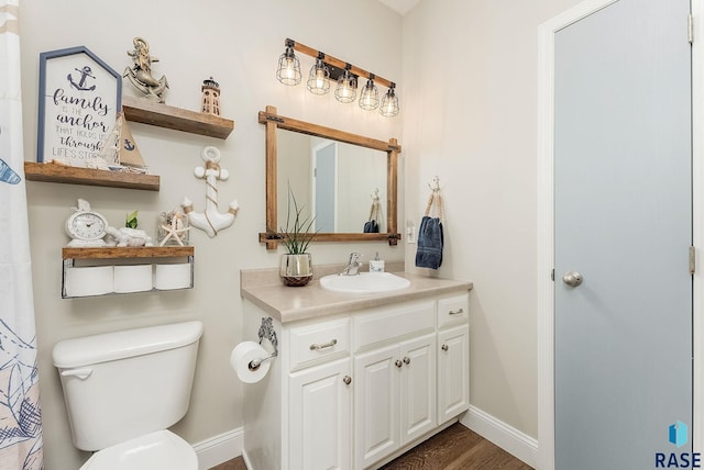 bathroom featuring toilet, vanity, and hardwood / wood-style floors