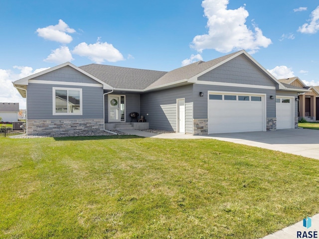 view of front of property with a front lawn, a garage, and central air condition unit