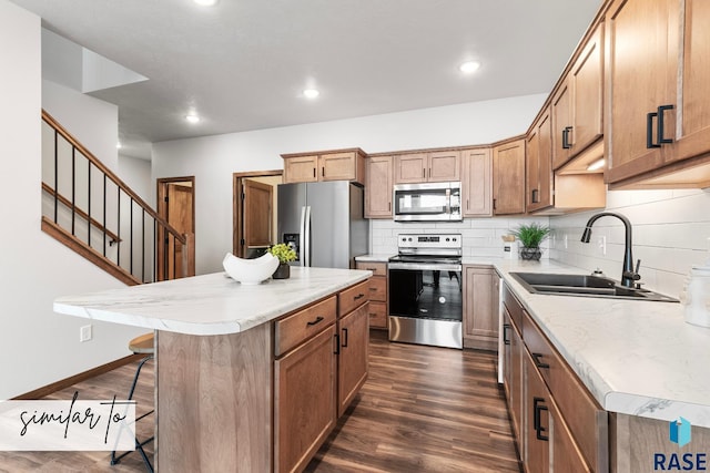 kitchen featuring a center island, sink, a kitchen breakfast bar, stainless steel appliances, and dark hardwood / wood-style flooring