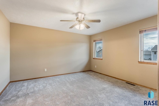 carpeted spare room featuring ceiling fan