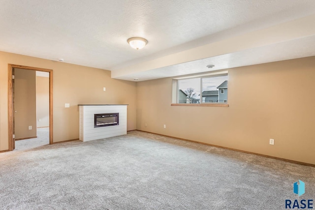 unfurnished living room featuring carpet floors and a textured ceiling