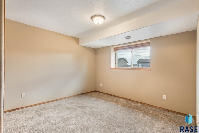 carpeted spare room with a textured ceiling