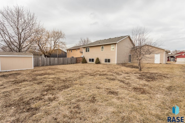 rear view of property featuring a lawn and a shed