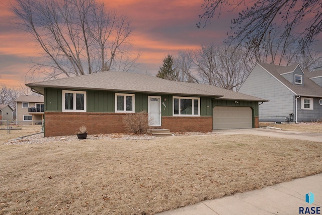 view of front of property with a garage and a lawn