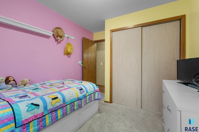 bedroom with light carpet, a closet, and a textured ceiling