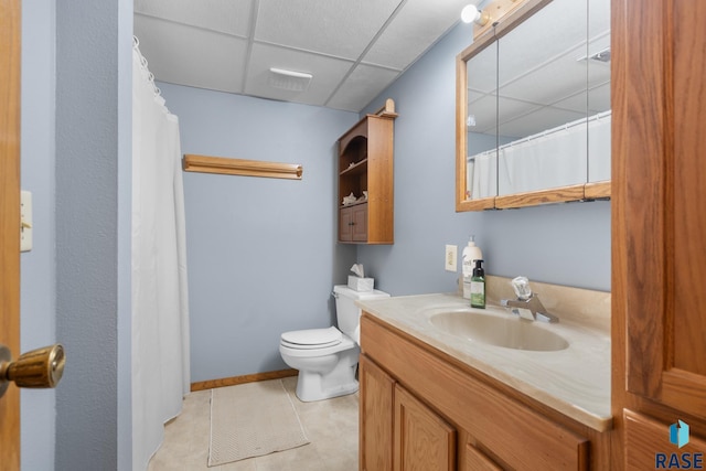 bathroom featuring vanity, a paneled ceiling, tile patterned floors, and toilet