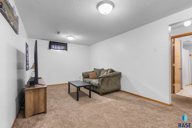 carpeted living room featuring a textured ceiling