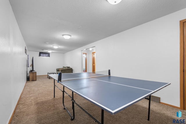 rec room with carpet and a textured ceiling