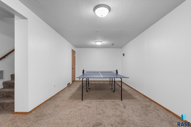 rec room featuring carpet flooring and a textured ceiling