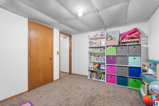 recreation room with a drop ceiling and carpet flooring