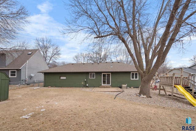 back of property featuring a playground