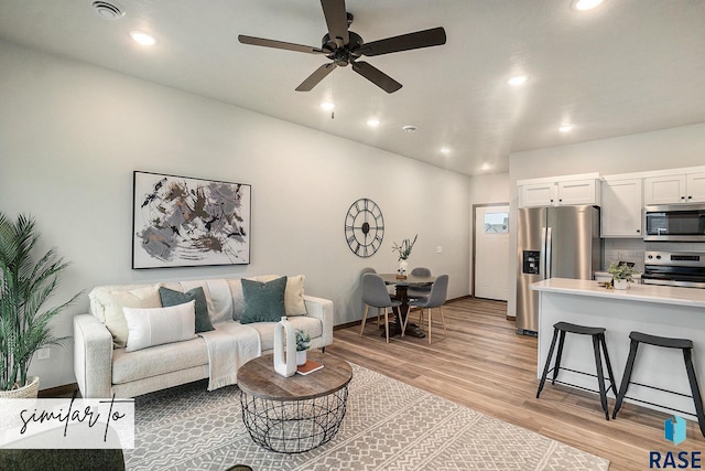 living room featuring light wood-type flooring and ceiling fan