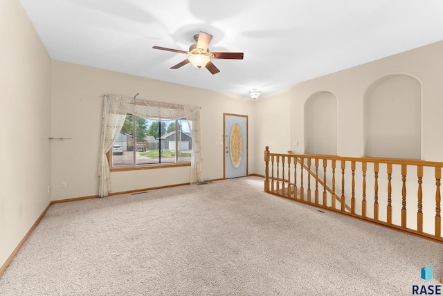 carpeted spare room featuring ceiling fan