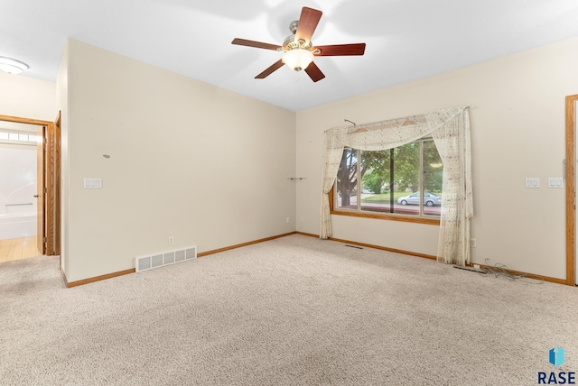 carpeted spare room featuring ceiling fan