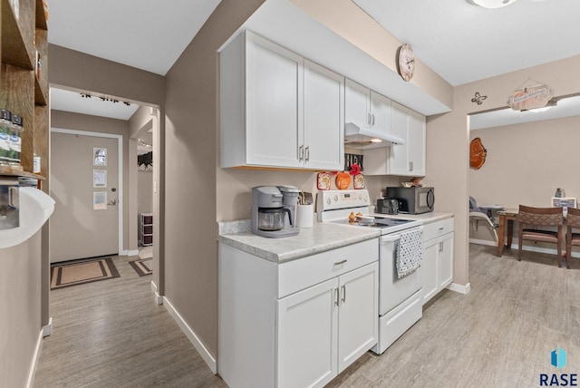 kitchen with white cabinetry, white electric range, and light wood-type flooring