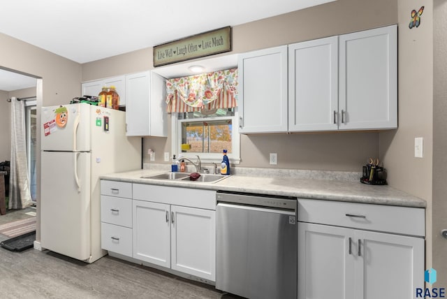 kitchen featuring white cabinets, white fridge, sink, stainless steel dishwasher, and light hardwood / wood-style flooring