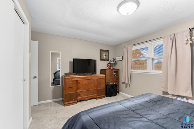 carpeted bedroom featuring a textured ceiling and a closet