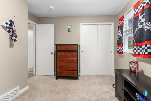 bedroom featuring light colored carpet and a closet