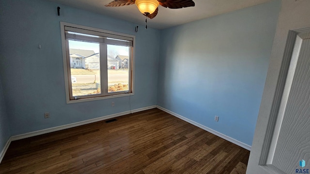 empty room with ceiling fan, a healthy amount of sunlight, and dark wood-type flooring