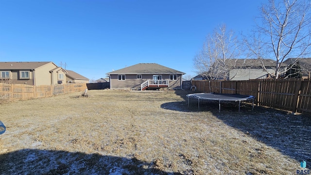 view of yard featuring a trampoline and a wooden deck