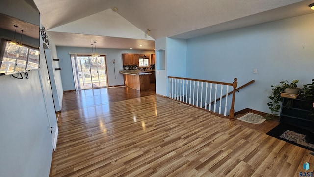 living room featuring high vaulted ceiling and light hardwood / wood-style floors