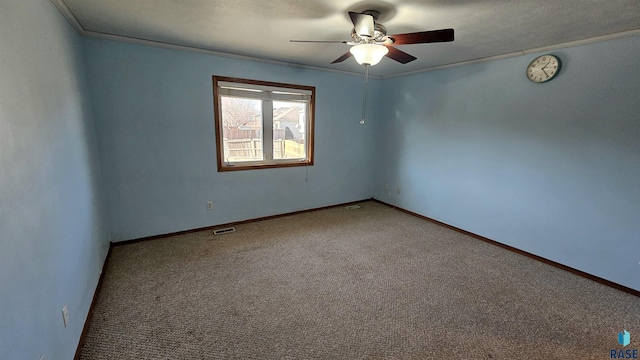 carpeted spare room featuring ceiling fan and crown molding