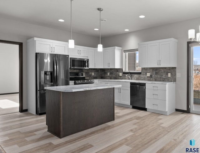 kitchen featuring appliances with stainless steel finishes, white cabinetry, hanging light fixtures, and a center island