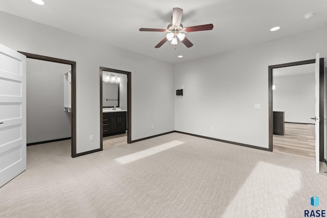 unfurnished bedroom featuring ensuite bath, sink, ceiling fan, and light carpet