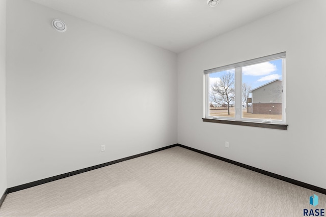 spare room featuring light colored carpet