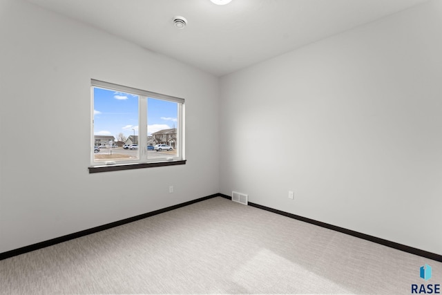 spare room featuring light colored carpet