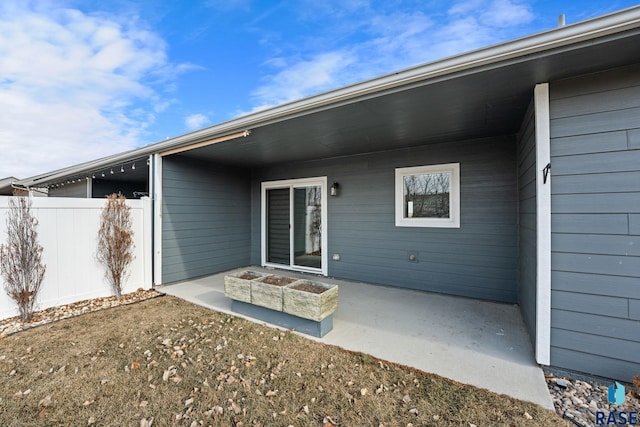 view of exterior entry with a patio area