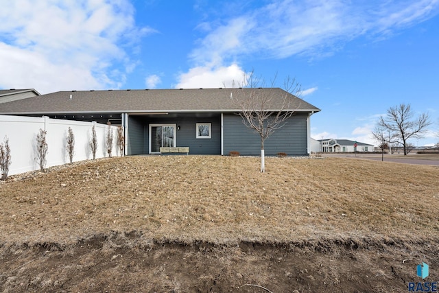 rear view of property featuring a lawn