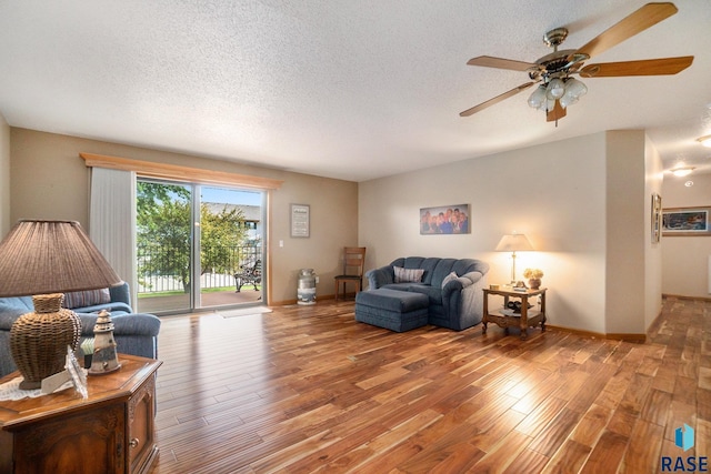 living room featuring a textured ceiling, ceiling fan, and hardwood / wood-style flooring