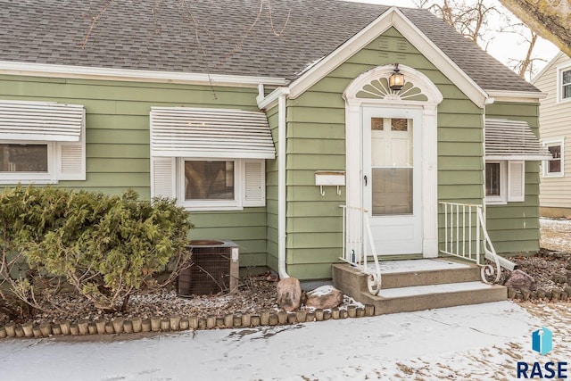 snow covered property entrance featuring cooling unit