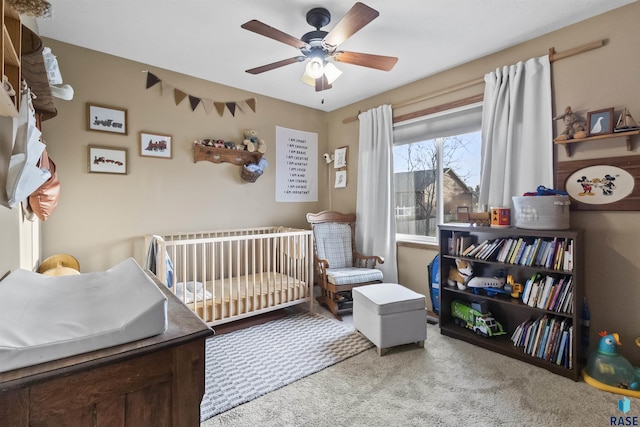 bedroom featuring ceiling fan, carpet floors, and a crib