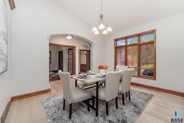 dining space featuring light hardwood / wood-style flooring, a chandelier, and vaulted ceiling